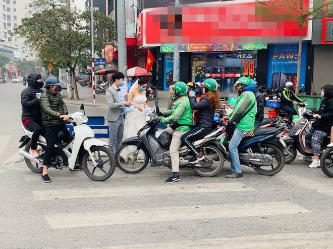Cô dâu chú rể phát khẩu trang miễn phí trên phố khiến dân mạng tranh cãi gay gắt - Ảnh 1.