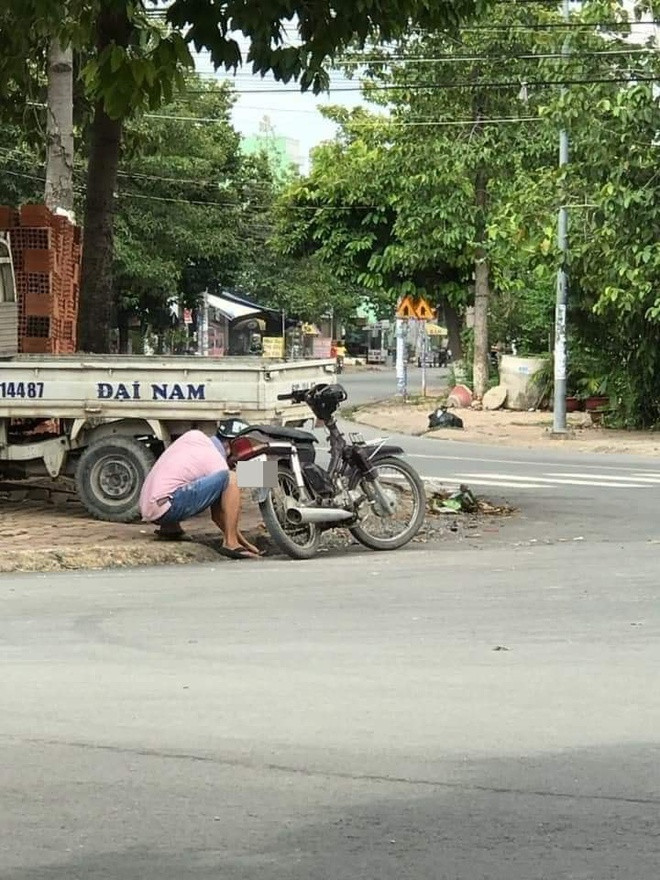 Người đàn ông dừng xe, lúi húi móc cống thoát nước, hành động tiếp theo không ai ngờ - Ảnh 1.