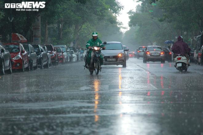 Tài xế xe ôm khơi thông cống thoát nước trên phố Hà Nội sau trận mưa lớn - 1