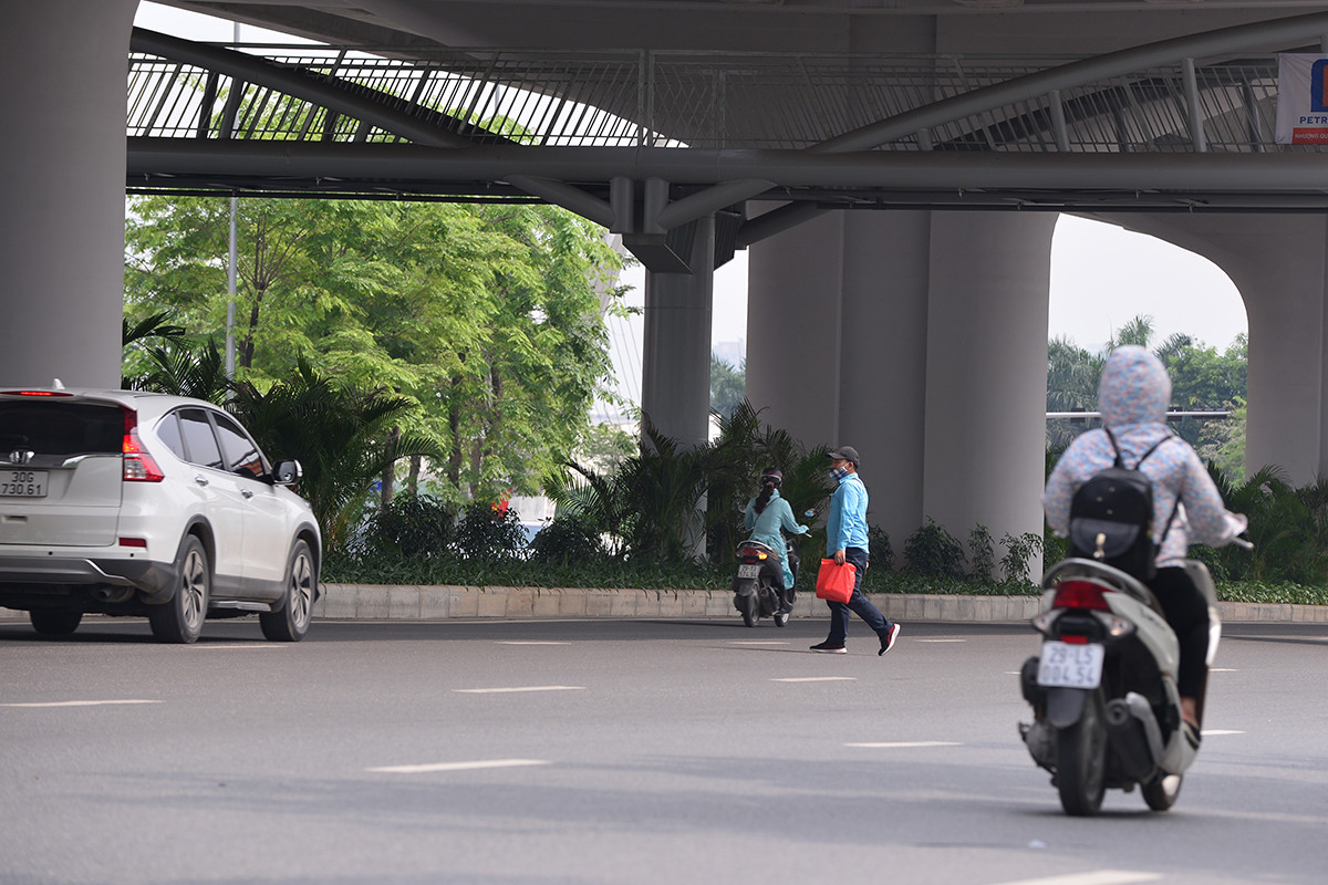 Hà Nội: Bất chấp nguy hiểm, nhiều người đi bộ không dùng cầu vượt, chọn cách băng qua 12 làn xe để sang đường Phạm Văn Đồng - Ảnh 1.