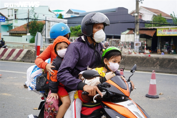 Ảnh: Những đứa trẻ theo cha mẹ vượt trăm cây số về quê bằng xe máy - Ảnh 10.