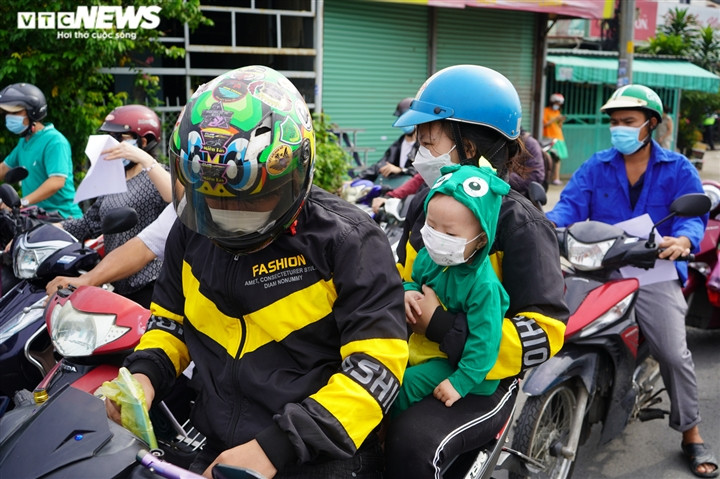 Ảnh: Những đứa trẻ theo cha mẹ vượt trăm cây số về quê bằng xe máy - Ảnh 7.