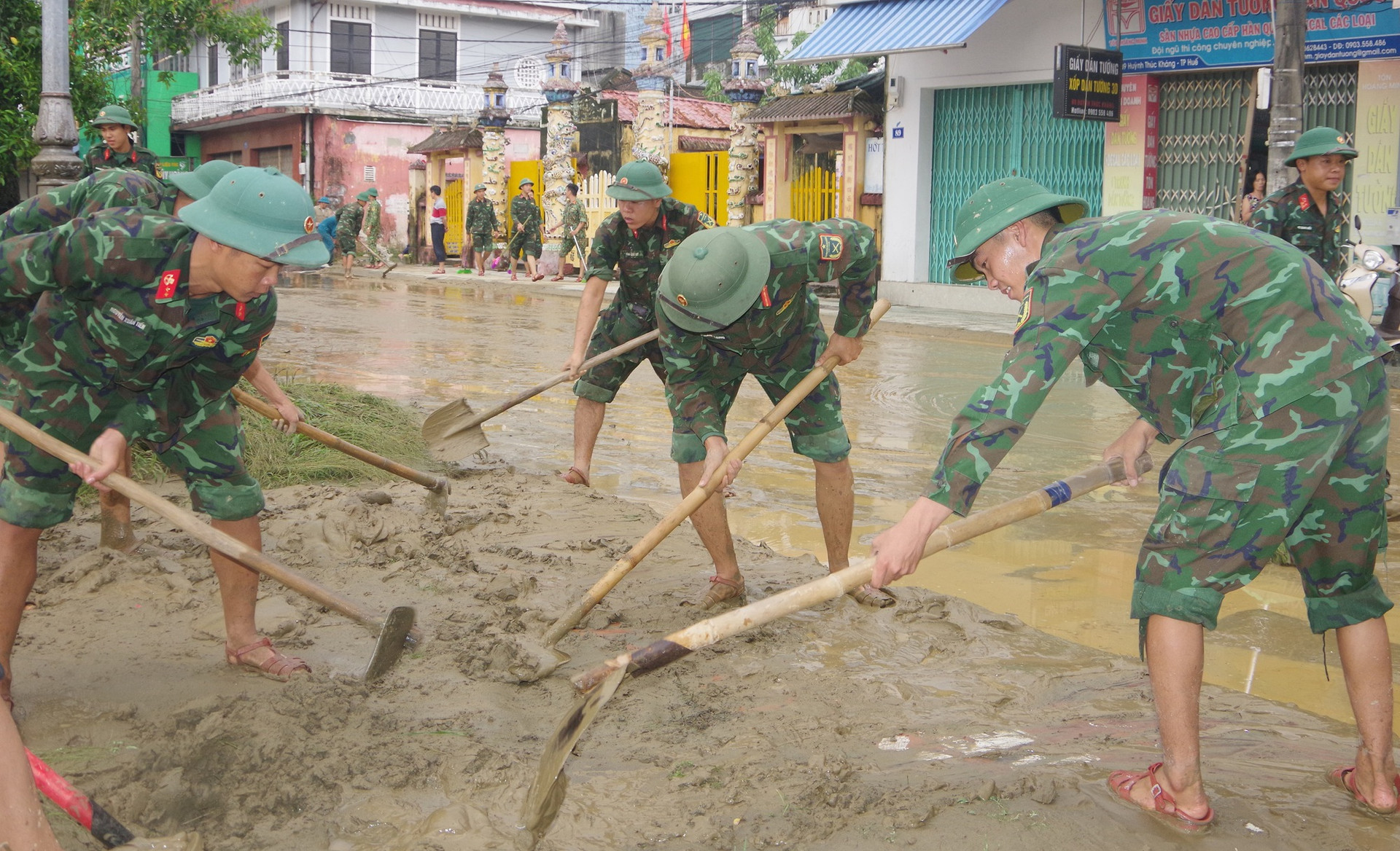 Bộ đội, công an chung tay dọn bùn đất sau mưa lũ - Ảnh 1.