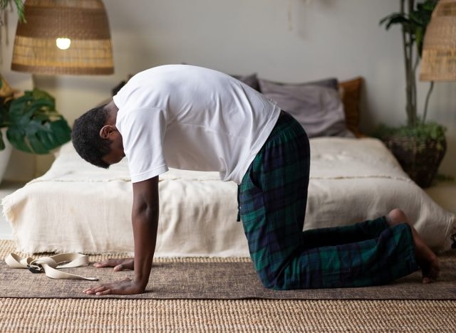 Người đàn ông trẻ châu Phi cơ bắp, khỏe mạnh đang tập luyện, yoga, pilates, rèn luyện thể lực, thực hiện tư thế con mèo