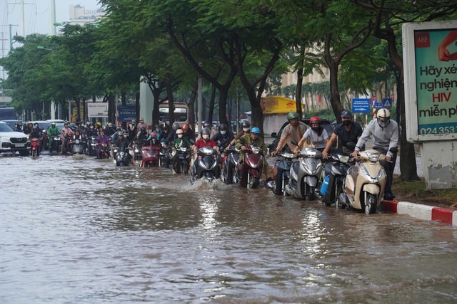 Người Hà Nội kiên nhẫn vượt ngập đến công sở- Ảnh 18.