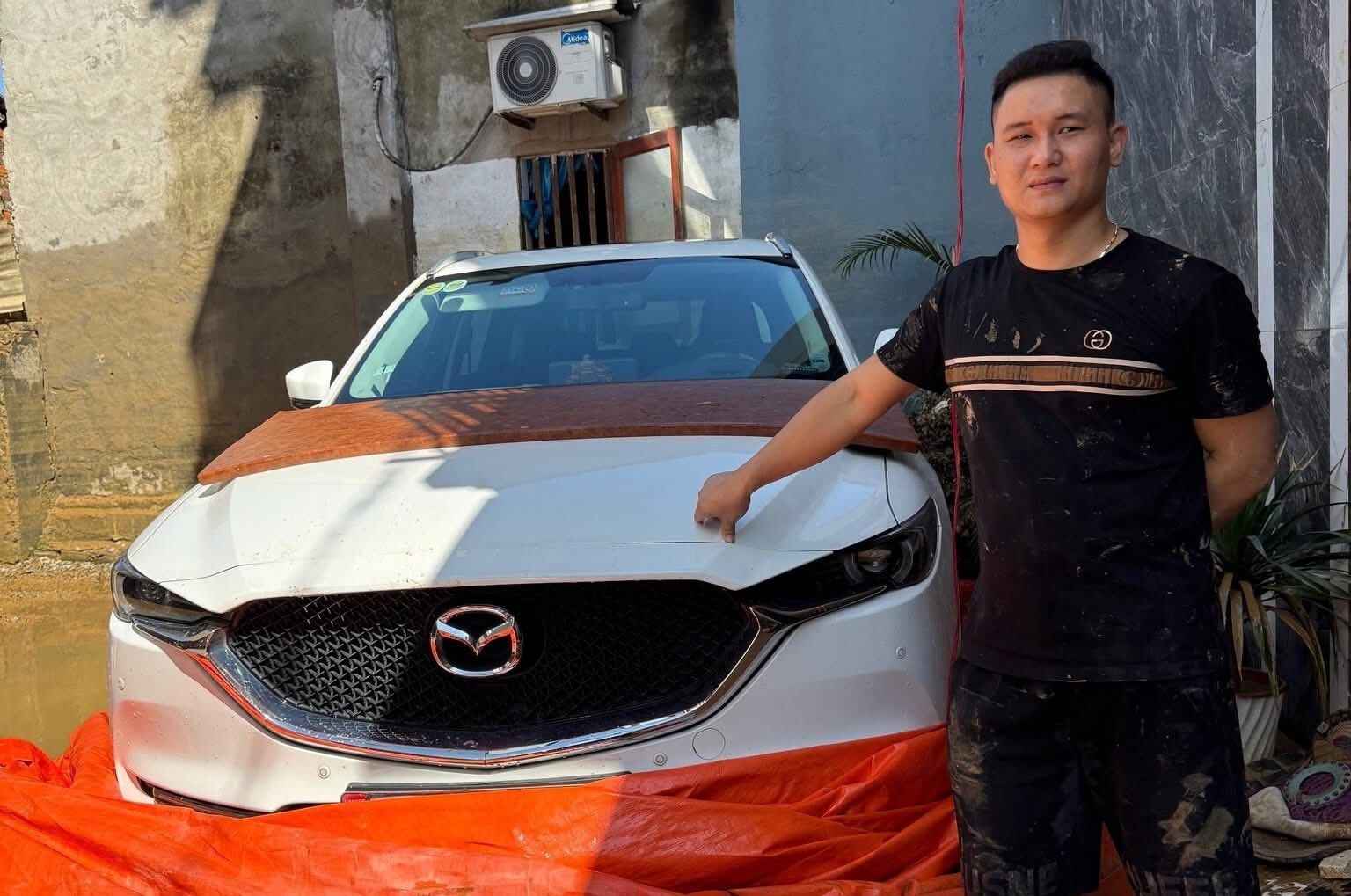 Anh Hoàng Thắng (Thái Nguyên) cùng chiếc xe được giữ an toàn với phương pháp bọc bạt. (Ảnh: FBNV)