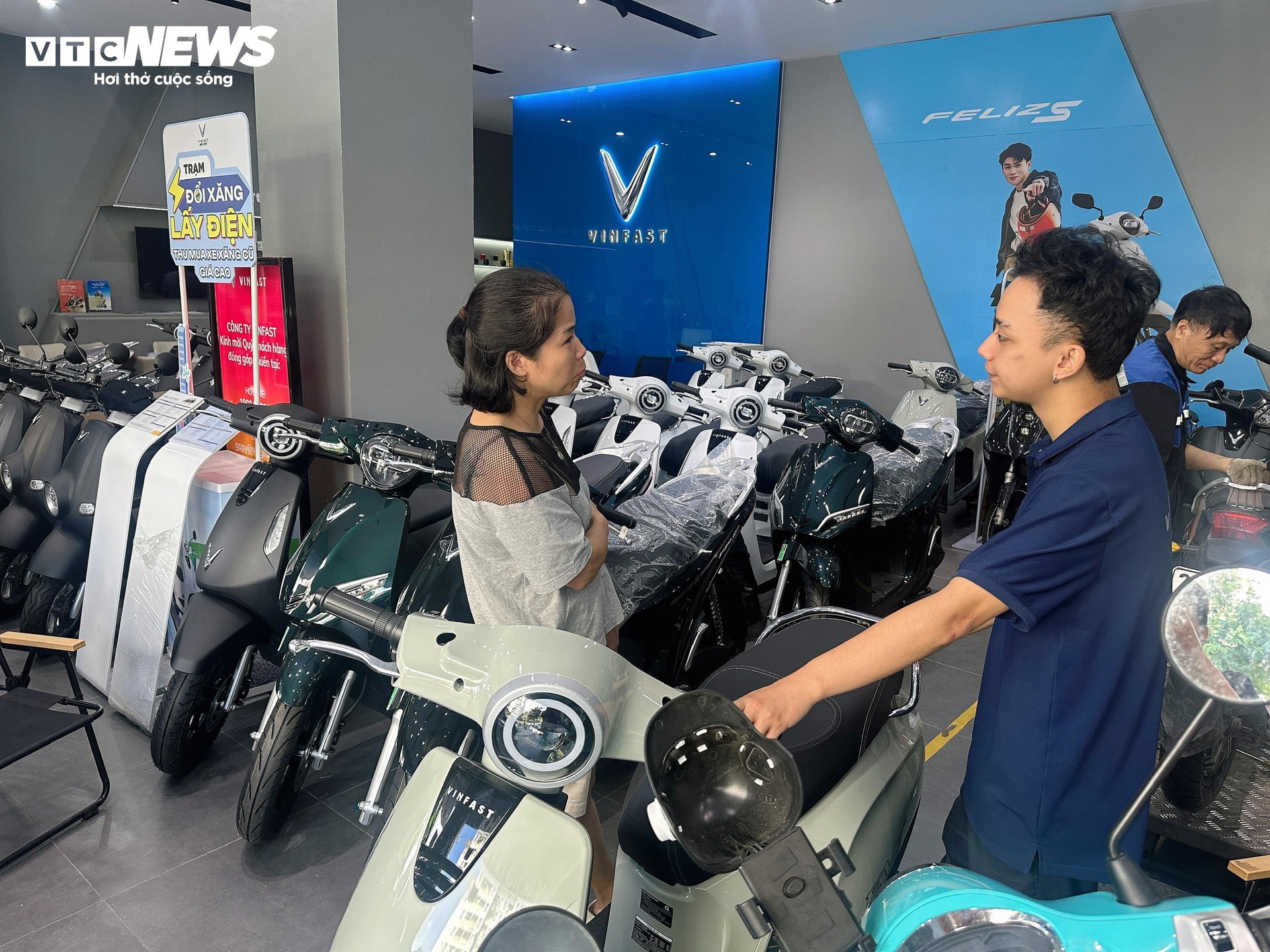 Chị Thu Hiền được nhân viên cửa hàng VinFast tư vấn, hướng dẫn về mẫu xe mới Evo Grand. (Ảnh: Mạnh Hùng)