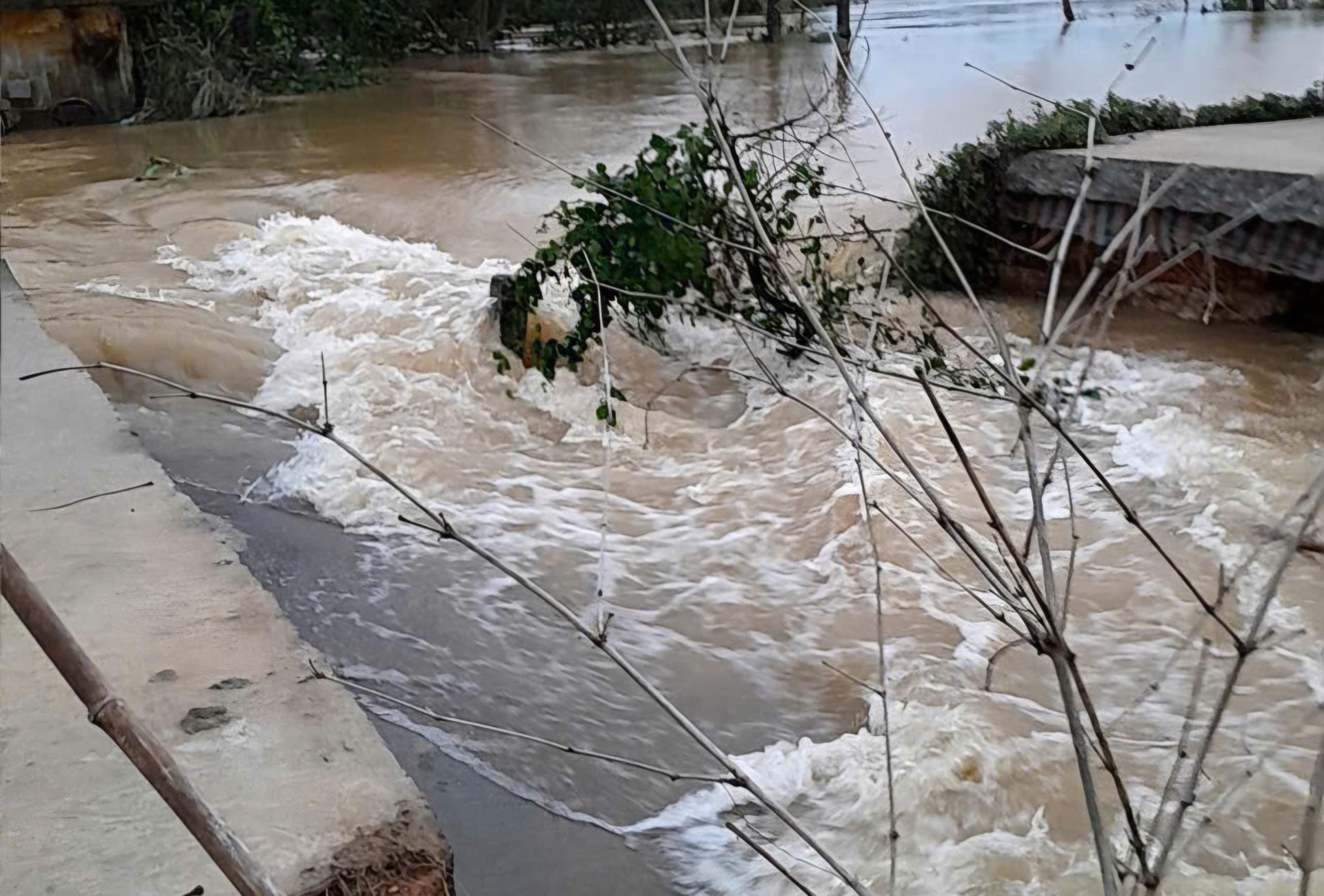 Nước lũ cuốn trôi đoạn đê kết hợp đường giao thông ở Huế- Ảnh 1.