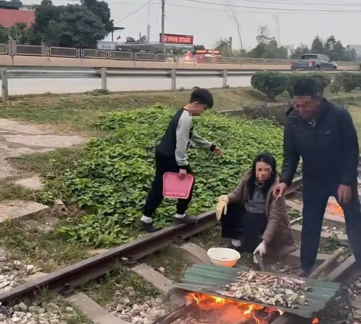 Xôn xao clip gia đình nổi lửa, nướng đồ ăn trên đường ray- Ảnh 1.