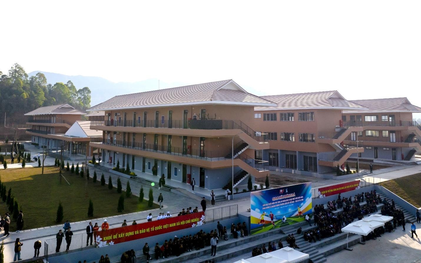 Sun Group cam kết đồng hành lâu dài và trao 2 tỷ đồng tài trợ trường liên cấp Si Pa Phìn, Điện Biên- Ảnh 1. A building with stairs and people in front AI-generated content may be incorrect.