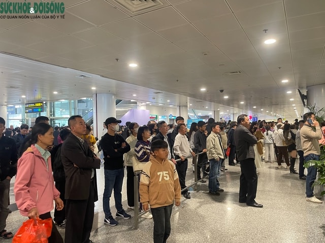 Sân bay Nội Bài chật kín người đón thân nhân về quê ăn Tết- Ảnh 1.