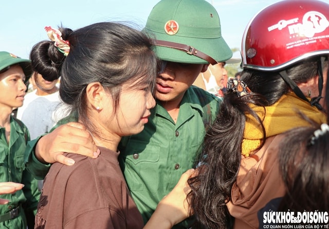 Tân binh ôm chặt người thân, bịn rịn chia tay để lên đường nhập ngũ. Ảnh: Duy Ngọc.