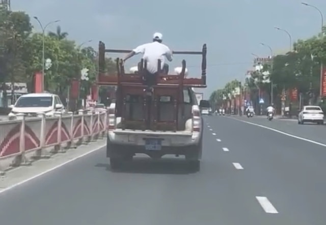 Xác minh ô tô biển xanh chở bàn ghế cồng kềnh, người ngồi trên thùng khi di chuyển- Ảnh 1.
