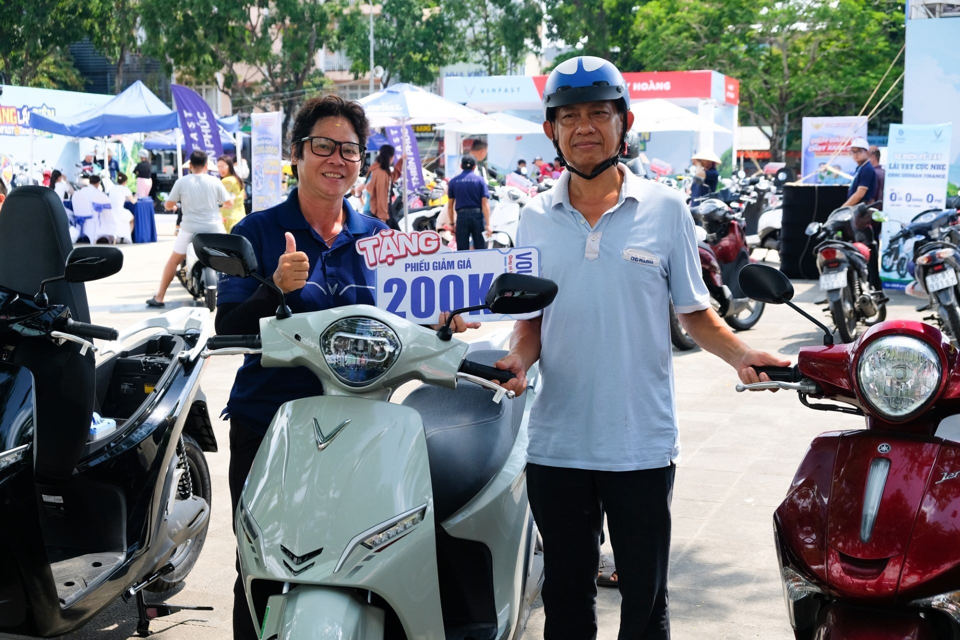 Ông Nhân đứng cạnh chiếc xe xăng cũ và VinFast Feliz 2025 mới được đổi tại sự kiện.