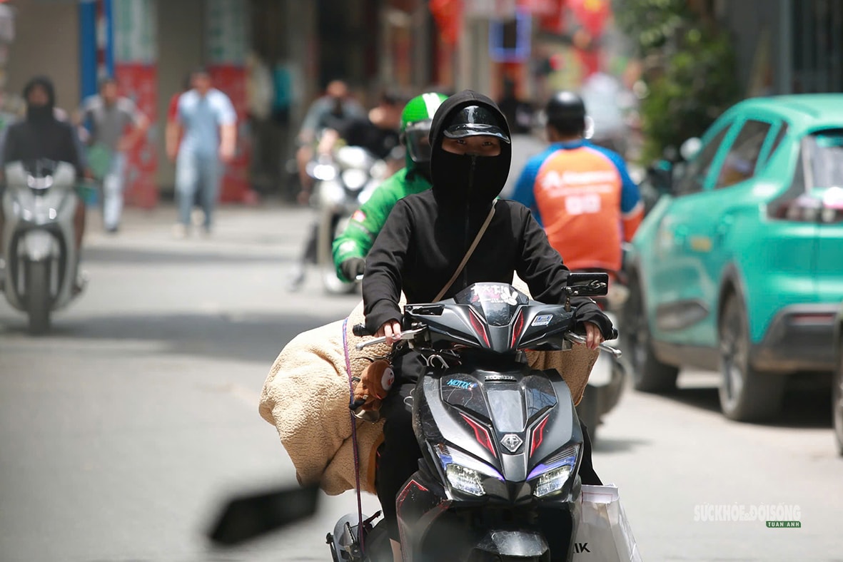 Hà Nội 'hầm hập' nắng nóng đầu mùa, người dân kín mít áo chống nắng ra đường- Ảnh 7.