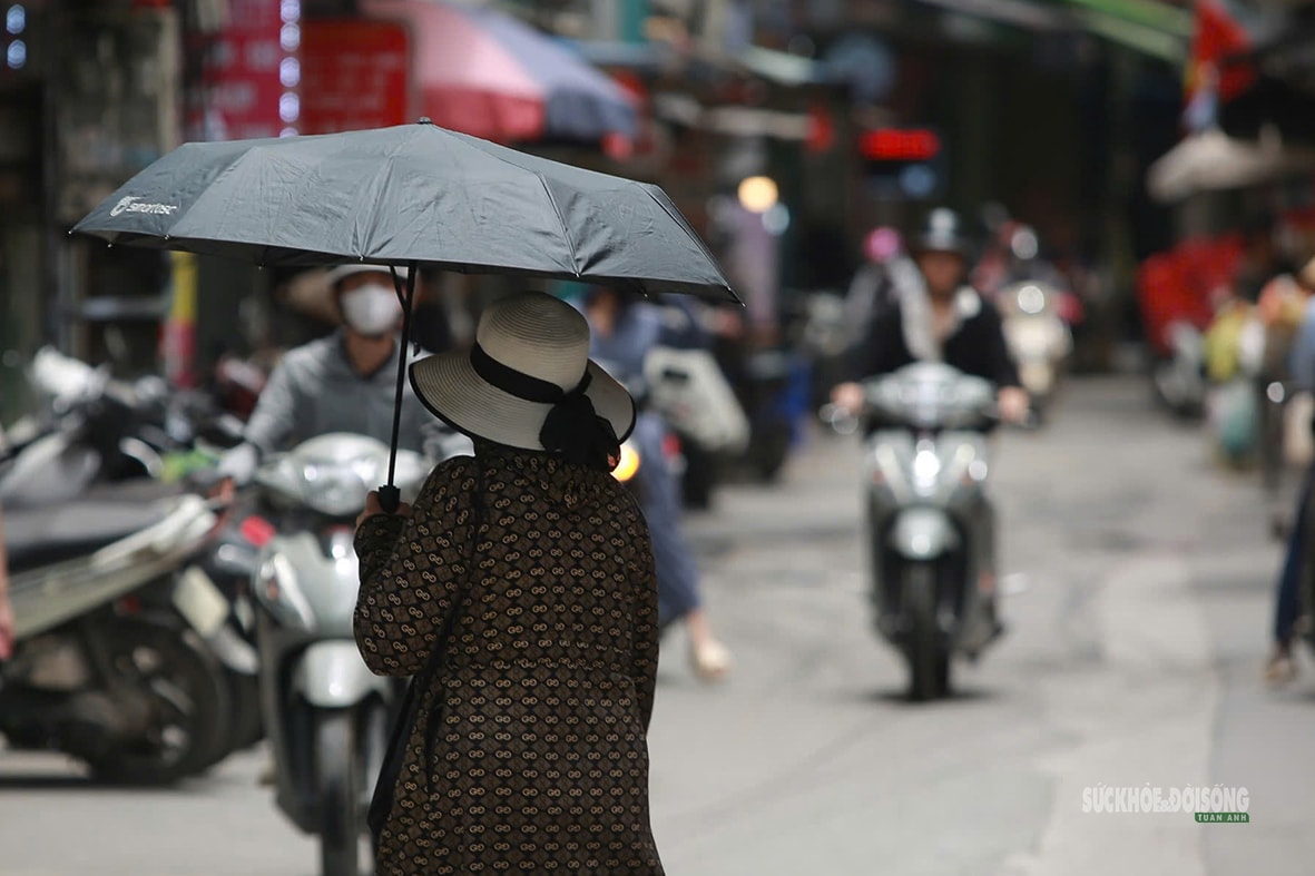 Hà Nội 'hầm hập' nắng nóng đầu mùa, người dân kín mít áo chống nắng ra đường- Ảnh 8.
