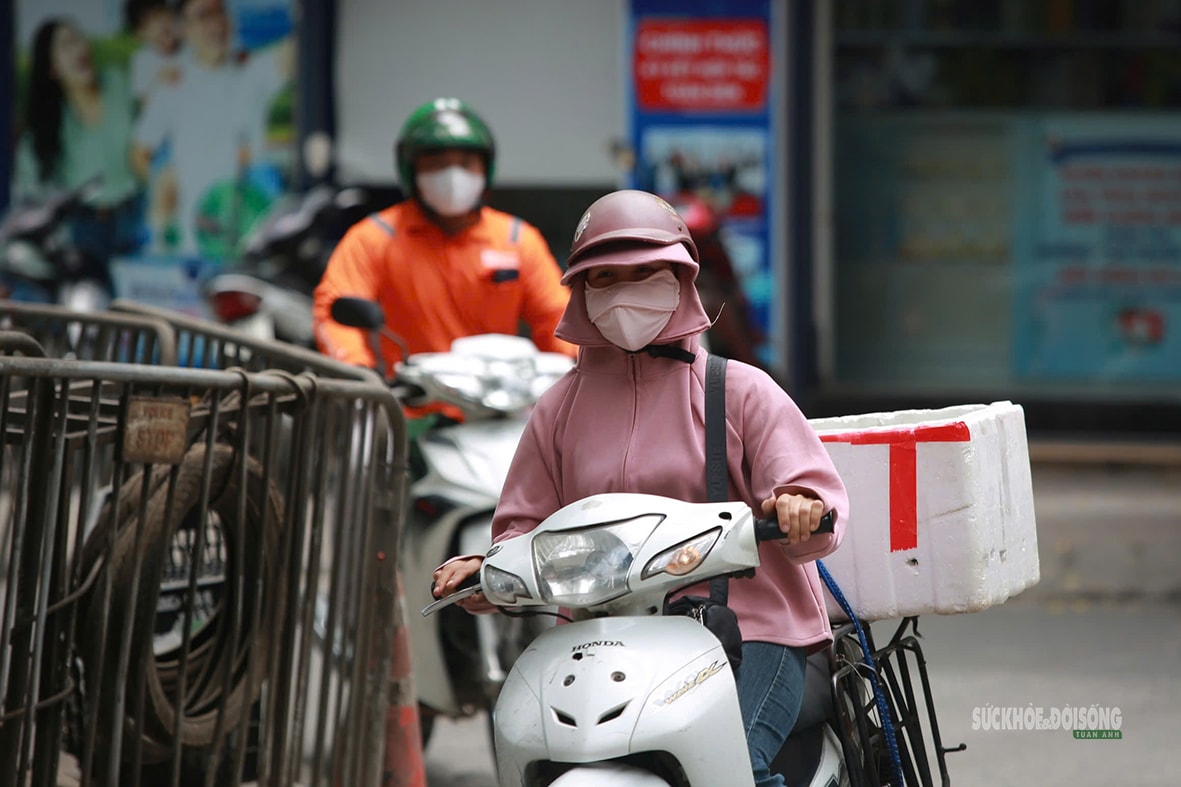 Hà Nội 'hầm hập' nắng nóng đầu mùa, người dân kín mít áo chống nắng ra đường- Ảnh 3.