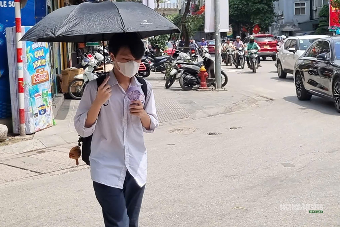 Hà Nội 'hầm hập' nắng nóng đầu mùa, người dân kín mít áo chống nắng ra đường- Ảnh 2.