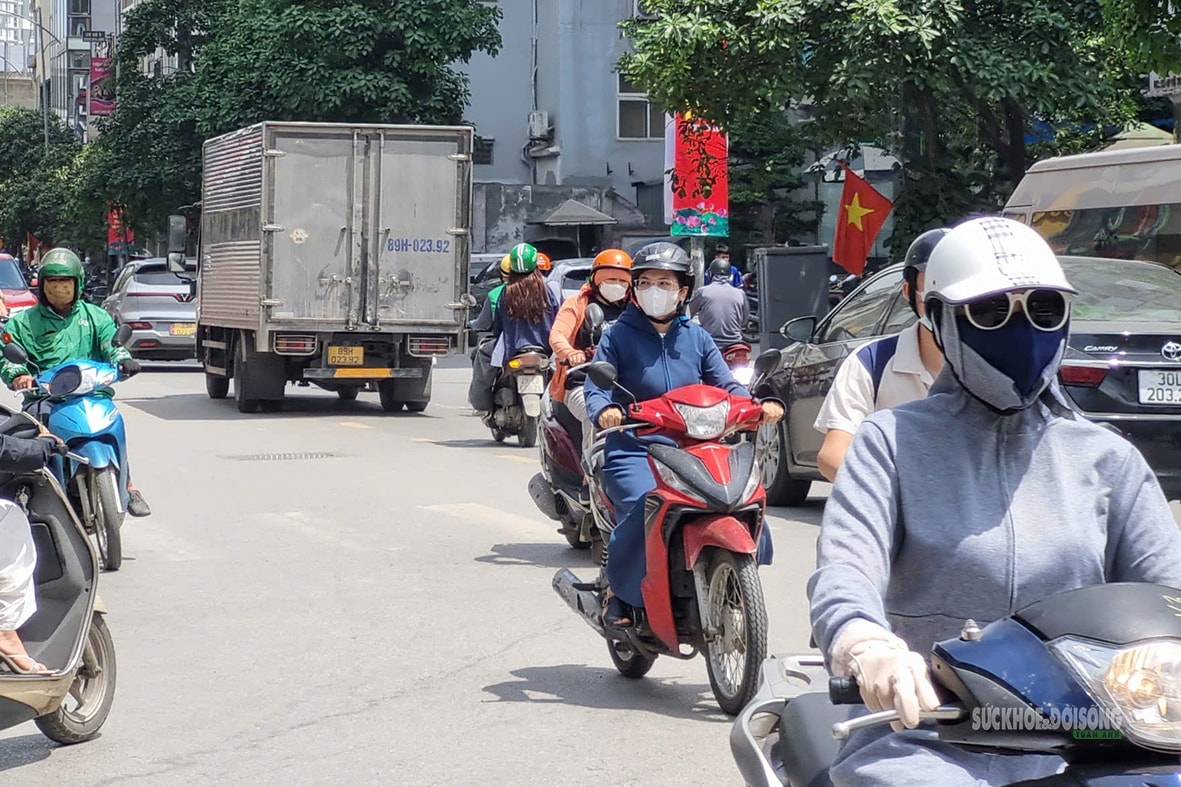 Hà Nội 'hầm hập' nắng nóng đầu mùa, người dân kín mít áo chống nắng ra đường- Ảnh 4.