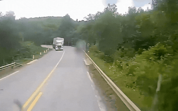 Video xe đầu kéo vào cua tốc độ cao, lật thùng đè ô tô làn ngược chiều- Ảnh 2.