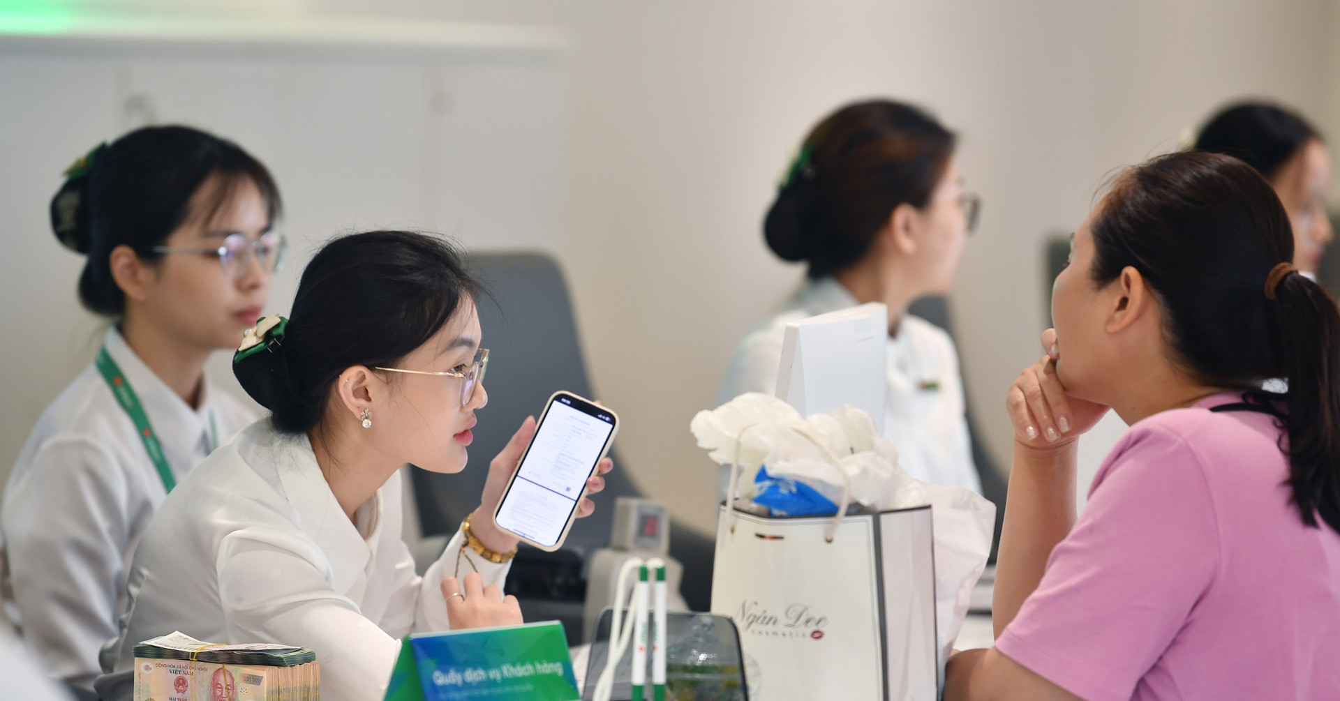 Khách hàng giao dịch gửi tiết kiệm tại quầy ngân hàng