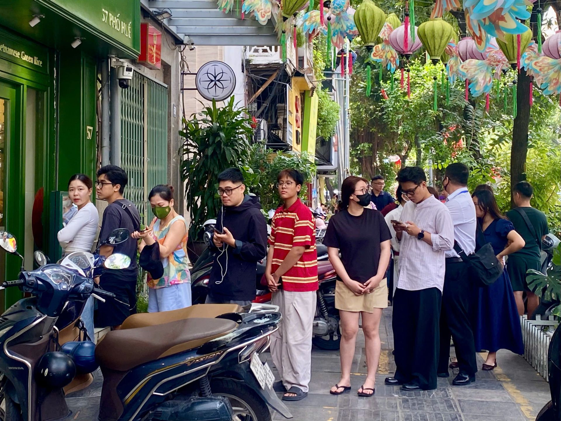 Người dân xếp hàng mua và nhận bánh Trung thu tại một cửa hàng trên phố Huế trong sáng ngày rằm