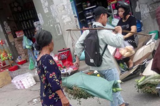 Hình ảnh chàng trai không ngại ngần giúp bác bán rau gánh hàng nhận nghìn like từ dân mạng