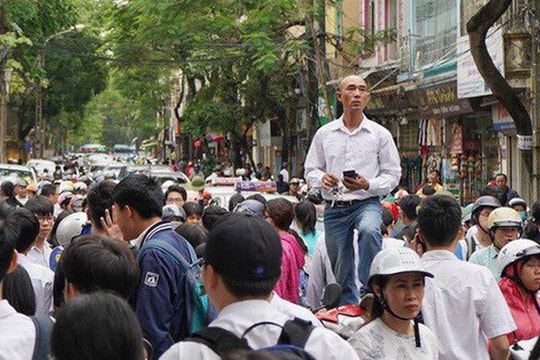 Bức ảnh ông bố trèo lên xe máy để tìm con giữa đám đông sau buổi thi gây sốt MXH