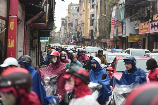 Ảnh: Xe cộ ùn tắc, người dân vất vả mưu sinh dưới trời mưa bão ở Hà Nội
