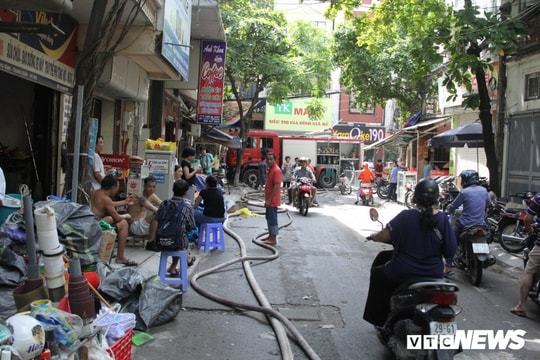 Ảnh: Người dân sống gần Công ty Rạng Đông uể oải thu dọn đồ đạc sau đêm vật lộn với "giặc lửa"