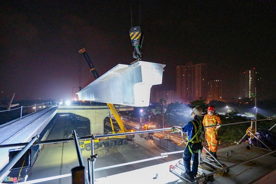 Ảnh: Máy cẩu xuyên đêm lắp đặt  phiến dầm 70 tấn ở công trường đường trên cao