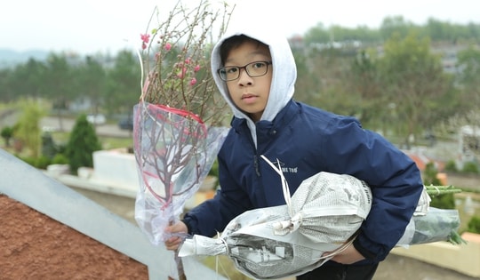 Người Hà Nội mang đào, quất lên nghĩa trang, mời 'các cụ' về đón Tết cùng con cháu