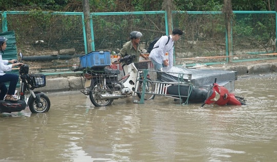 Đoạn đường gom Đại lộ Thăng Long bị ngập trong nước, người dân di chuyển chật vật