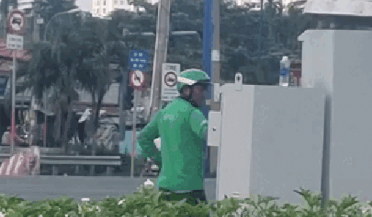 Xôn xao cảnh người đàn ông mặc áo xe ôm công nghệ đứng điều chỉnh đèn tín hiệu giao thông