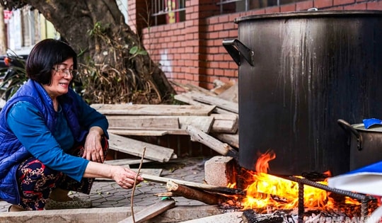 Người Hà Nội bắc bếp củi luộc bánh chưng trên hè phố
