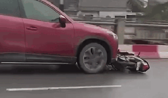 Ô tô kéo lê xe máy trên phố Hà Nội sau va chạm giao thông