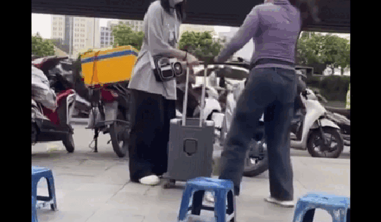 Người phụ nữ bán nước ở bến xe Mỹ Đình xua đuổi, đá hành lý của cô gái đợi xe trên vỉa hè