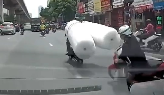 Thót tim xe máy chở hàng cồng kềnh khiến người phụ nữ ngã vào gầm ô tô
