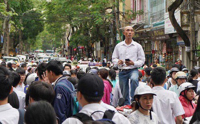 Bức ảnh ông bố trèo lên xe máy để tìm con giữa đám đông sau buổi thi gây sốt MXH