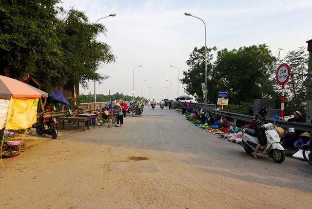 Ảnh:  Người dân biến cầu tỉnh lộ ở Hà Nội thành nơi họp chợ, phơi thóc
